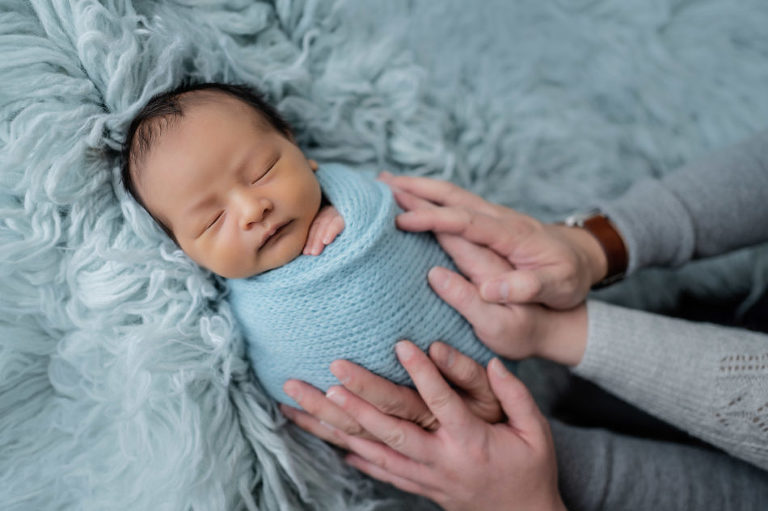 parent hands with newborn